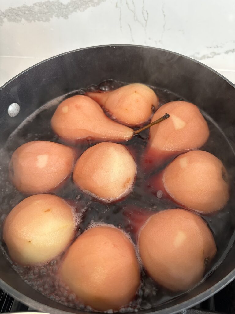 Rotate Pears while simmering Pomegranate Pistachio Poached Pears