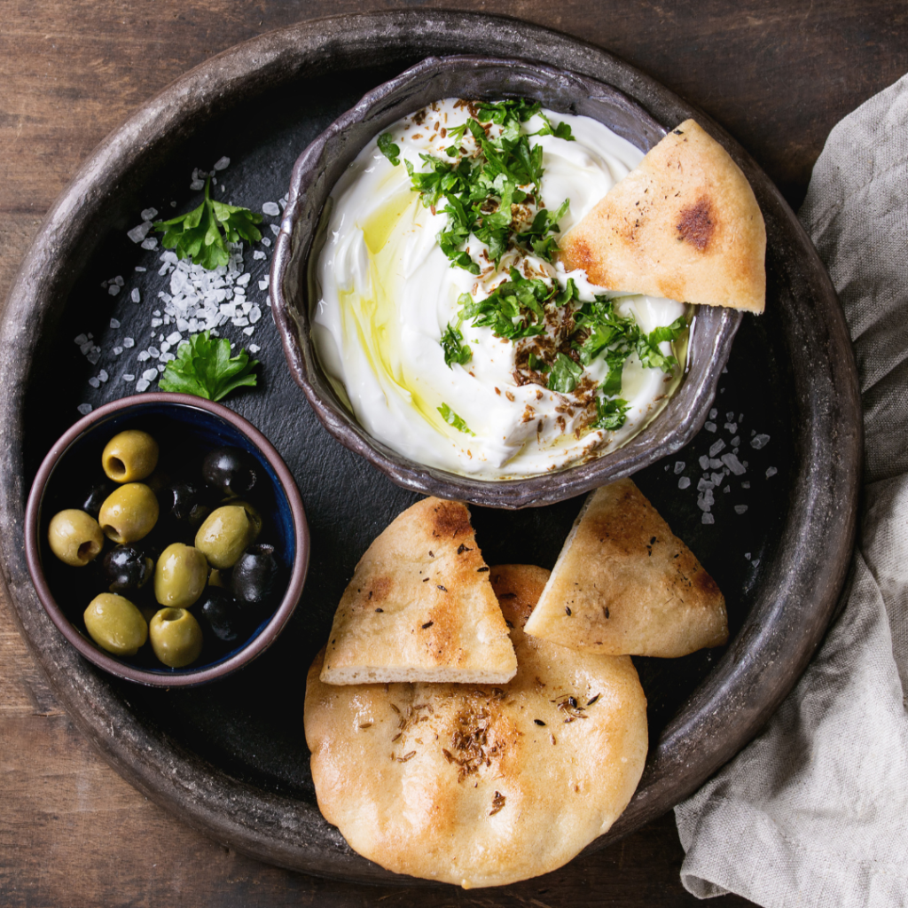 Delicious Appetizer of Fresh Bread, Persian Shallot Yogurt Dip, Olives and Herbs