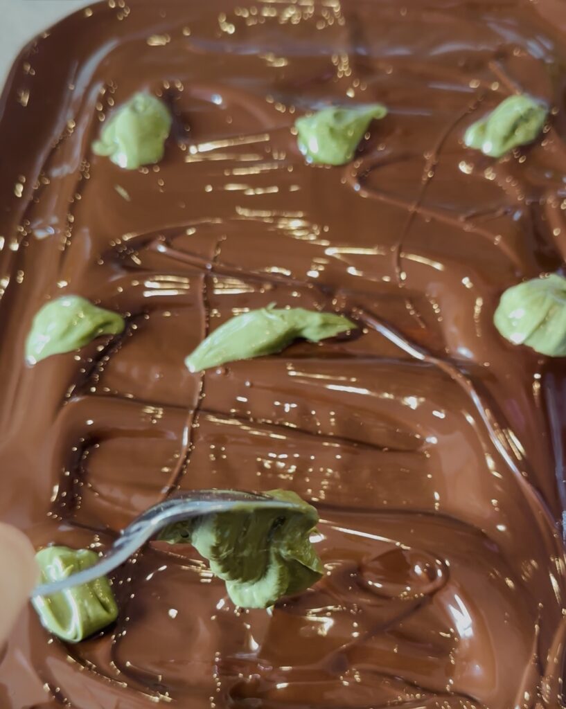 Dollop pistachio cream over melted chocolate and get ready to swirl you Dubai Chocolate Pistachio Bark